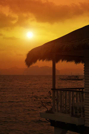tropical sea bungalow' porch  at sunsetの写真素材