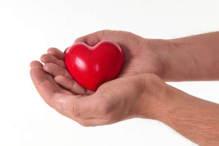 Male hands holding a shiny red heart isolated on white background