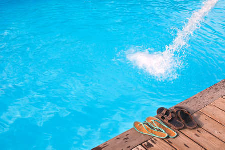 Romantic vacation near swimming pool with Two pairs of flip-flops by swimming pool in luxury hotelの写真素材