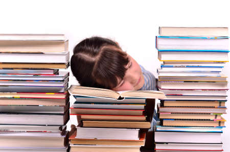 Little gire reading a book sleeping among stacks of books isolated on white background