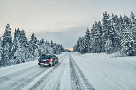 Taxi overtaking on a slippery winter road in Laplandの写真素材