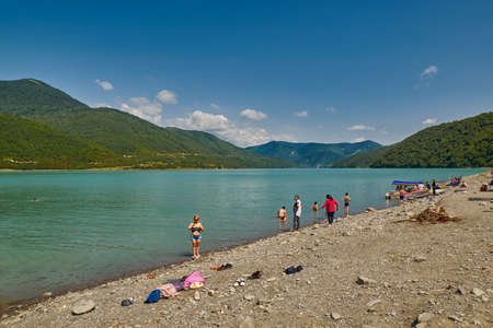 ANANURI, GEORGIA - 29 July 2017: People relaxing on Zhinvali Lake Beach near Ananuri Castle in Georgiaのeditorial素材