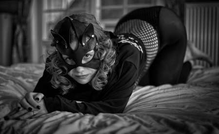 Seductive cat-woman in sexy costume in artistic grayscale bedroom settingsの写真素材