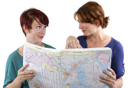 two young women are lost and looking at a mapの写真素材