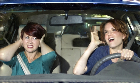 annoyed passenger and singing female driverの写真素材