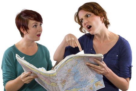 two young women are lost and looking at a mapの写真素材