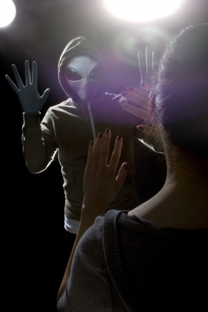 Gray alien with lights behind abducting a young womanの写真素材