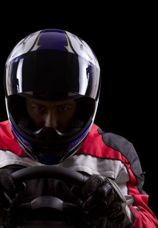 racerwearing red racing suit and blue helmet on a steering wheelの写真素材