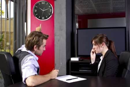 Male boss angry at late female employeeの写真素材