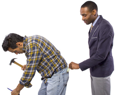 Businessman Stealing from a Blue Collar Workerの写真素材