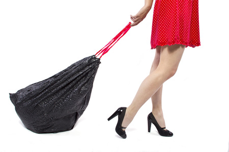 woman cleaning up and holding a black trashbagの写真素材