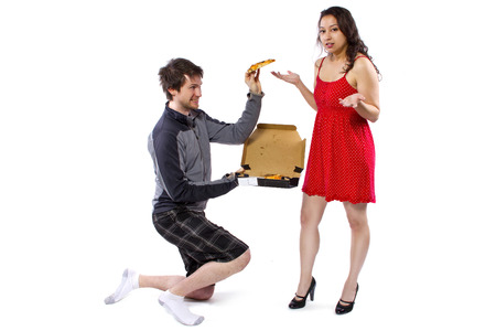 comedic unusual delivery boy offering pizza to girlの写真素材