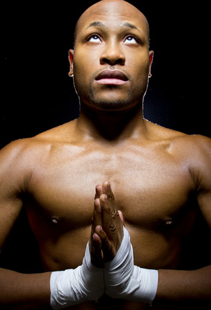 black mma fighter preparing to fight  by praying with hands claspedの写真素材