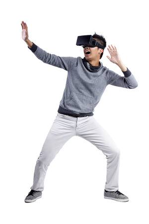 Male immersed in interactive virtual reality video game doing gestures on white backgroundの写真素材