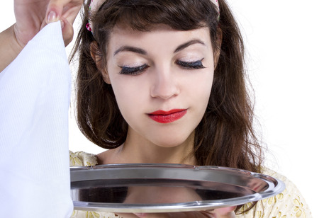 Retro style female waitress unveiling a surprise hidden in a tray and napkinの写真素材