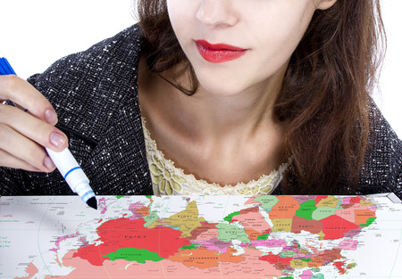 Female holding a pen and writing on a map for travel plans