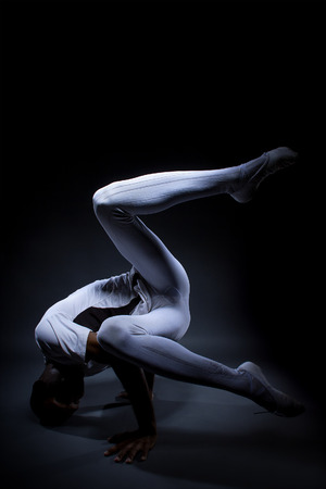 Black male dancer practicing warm up exercises for flexibility