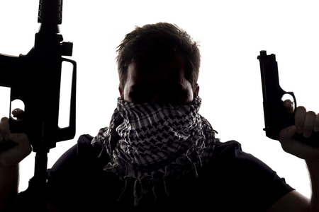 Ambiguous silhouette of a terrorist or a soldier with a rifle and a handgun