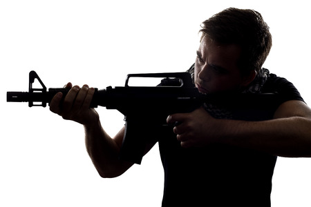 Silhouette of a model posing as a military soldier with a rifle and shemagh scarfの写真素材
