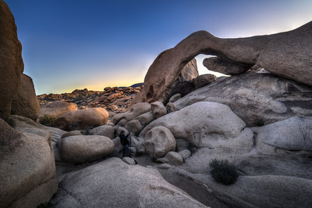 Landscape photographer hiking or trekking in a rocky desertの写真素材