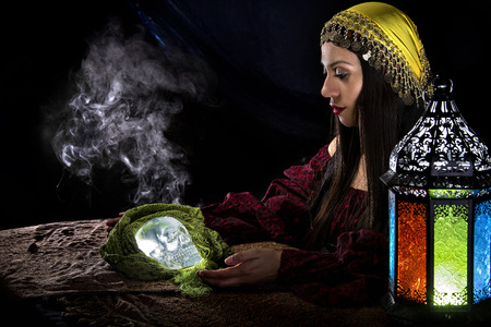 Female psychic or fortune teller holding a crystal skull trying to communicate with the deadの写真素材