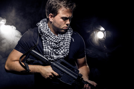 Soldier or mercenary wearing a shemagh with assault rifle, paintball or airsoft gun.  The image also...