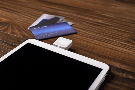 Credit card payment on a swipe or chip reader app on a tablet used by small or online businesses.  The electronic device is used as a modern cash register or for banking.の写真素材