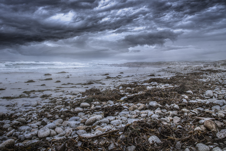 Foggy view of Pebble Beach California coast with storm clouds and rough seas causing waves to crash on rocks.  The picture depicts the Pacific Ocean and tourism in Monterey America. The beach is shaped by erosion and climate change.の写真素材