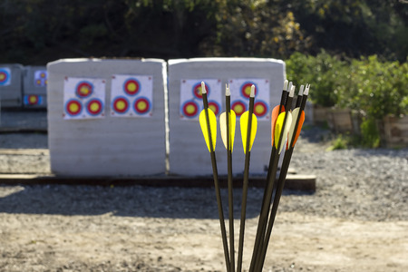 Archery or shooting range with bow and arrows on a sunny outdoor setting.  The equipment is used in competitive sports and as a traditional weapon.  The circular targets are what the archer shoots.の写真素材