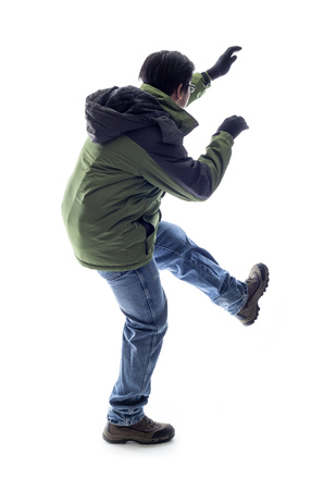 Mountain climber or hiker isolated on a white background for composites.  The man is acting like he is climbing something and depicts adventure and extreme sports.の写真素材