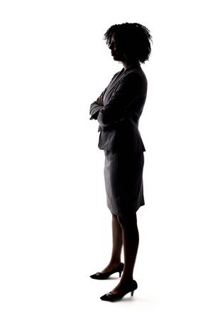 Silhouette of a Black Businesswoman posing as a confident leader or arrogant person.  She is isolated on a white backgroundの写真素材