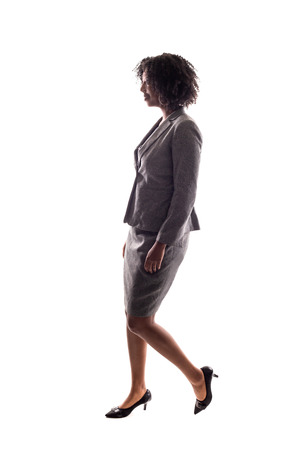 Side View of a Black Businesswoman walking in side view isolated on a white background.の写真素材