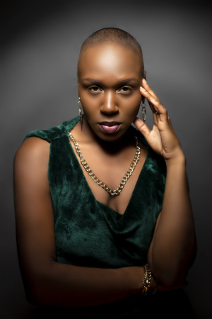 Black African American female fashion model with a bald hairstyle in a studio.  The portrait shows the beauty and confidence of the bold and trendy glamour hairdo style.  の写真素材