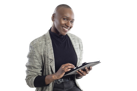 Black African American female teacher preparing her course or lessons online with a tablet computer.  She can aslo be a businesswoman preparing her outline for a seminar.の写真素材
