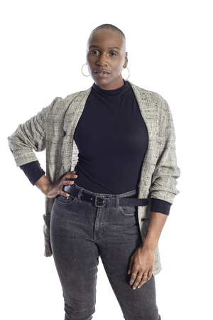Black African American woman looking confident while wearing modern business casual outfit on a white background.  The businesswoman is depicting bold urban fashion style.の写真素材