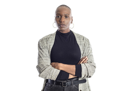 Black African American woman looking confident while wearing modern business casual outfit on a white background.  The businesswoman is depicting bold urban fashion style.の写真素材