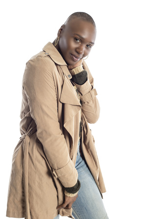 Confident black African American female model wearing Fall or Spring style fashion with a jacket or coat and jeans.  She has a bald hairstyle and isolated on a white background.の写真素材