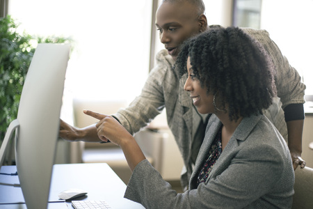 Black African American businesswomen or coworkers together in an office doing teamwork or job...