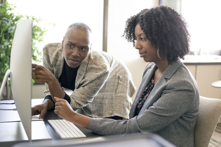 Black African American female co-workers having a business problem and annoyed or upset at each other.  The women lack teamwork or made a mistake at work.の写真素材