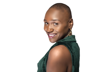 Beautiful black African American female model posing confidently with bald hairstyle on a white background.  The woman is portraying uniqueness and individuality.の写真素材