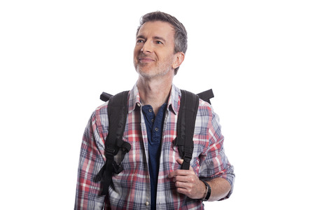 Middle-Aged man doing healthy activities during retirement by hiking or trekking or walking as a tourist when traveling.  He looks confident and happy carrying a backpack on a white background.の写真素材