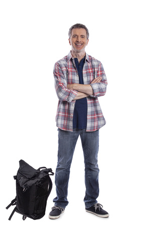 Middle-Aged man preparing a backpack for hiking or trekking.  He could also be a tourist packing hand carry luggage in preparation for a journey.の写真素材
