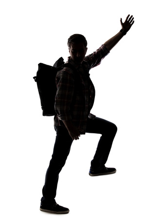 Silhouette of a hiker or mountain climber reaching to move up an imaginary mountain. The image depicts gestures or shape of an active man exploring.の写真素材