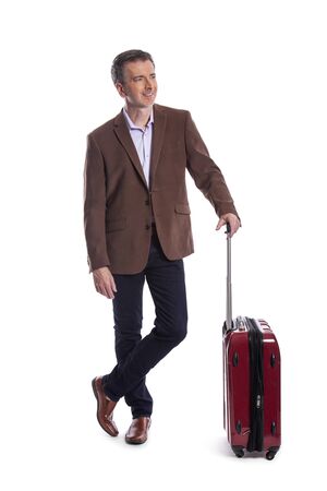 Traveling businessman going on a business trip.  He is waiting with luggage as if he is in the airport departure or arrival. Isolated on white background for composites.の写真素材