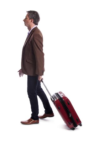 Businessman going on a business trip and traveling with luggage.  The man is carrying bags like preparing to board a flight at an airport.の写真素材