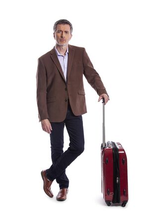 Traveling businessman going on a business trip.  He is waiting with luggage as if he is in the airport departure or arrival. Isolated on white background for composites.の写真素材