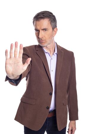 Middle aged bearded businessman on a white background wearing a brown jacket.  The mature man looks like a business executive holding hands up for stop gesture.の写真素材