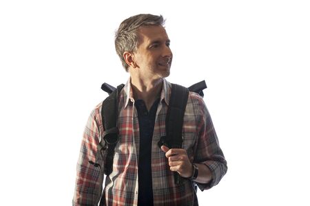 Middle-Aged male tourist with a backpack walking during sunset.  He is isolated on a white background for composites.  It depicts healthy lifestyle activities for older mature men.の写真素材