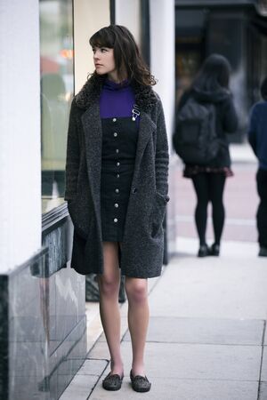 Woman walking outdoors in a city. She is window shopping and looking at a store sale advertising or marketing apparel and clothing on a display glass. の写真素材