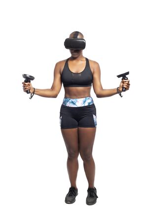 Athletic black female gamer wearing a vr headset and exercising in a virtual reality gym for weight loss.  The image depicts technology used in sports and esports entertainment for healthy lifestyle.の写真素材